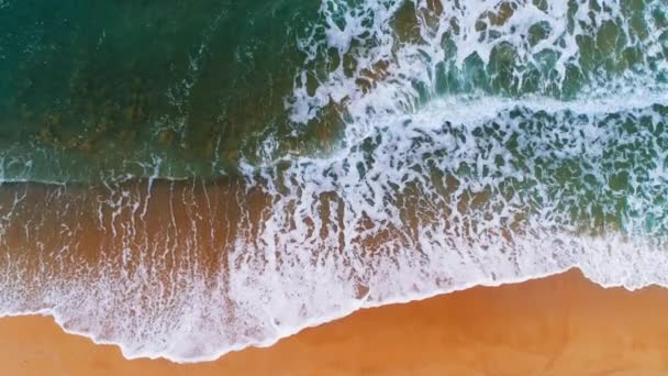 Vue aérienne des vagues de mer éclaboussant la plage. Fond bleu d'eau