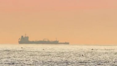 Deniz doğuyor ve konteynırlarla kargo gemisine biniyor.