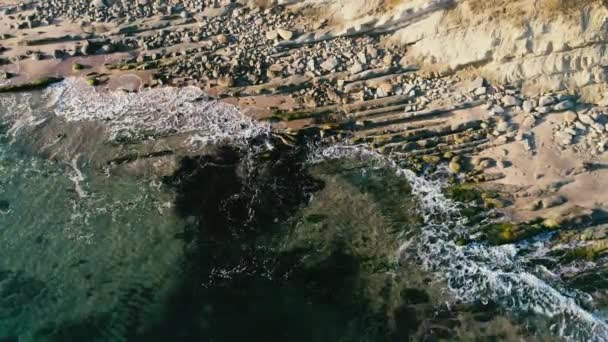 Côte océanique avec des pierres sur le rivage. Lever de soleil sur la plage.