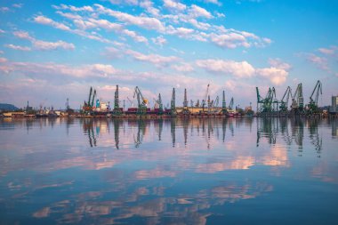 Deniz limanı ve endüstriyel vinçler. Gölün ve Karadeniz kıyısının üzerinde gün doğumu