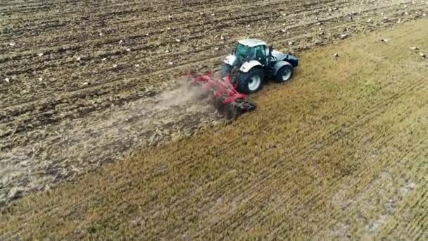 Traktor und Störche füttern auf einem Feld, Agrarlandschaft aus der Luft