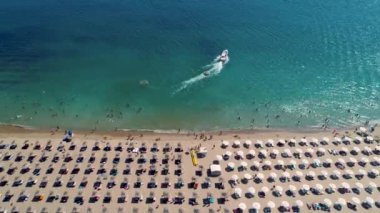 Deniz, sahil, kum, şemsiye ve su sporları aktivitelerinin havadan görünüşü. Yaz deniz manzarası.