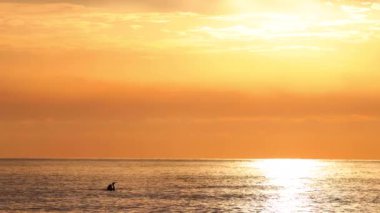 Altın okyanus gündoğumu, yanan gökyüzü dramatik bulutlarla su üzerinde