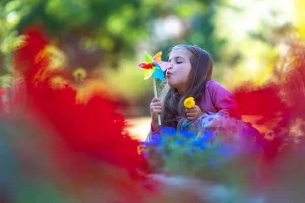 Jovem Feliz Jogando Soprando Pinwheel Parque Com Flores Coloridas Câmera — Fotografia de Stock