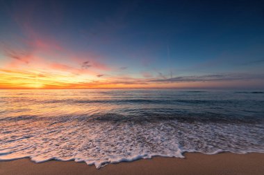 Deniz ufkunda ve sahil kıyısında güzel bir gün doğumu.
