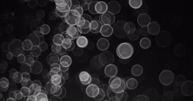 Soyut Kar ve Beyaz Kar Taneleri Bokeh Çemberleri mevsimlik ve bayramlık siyah bir arka plan videosunun üzerine düşüyor