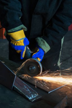 Öğütücüyle metal kesen bir işçi