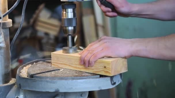 El hombre está perforando bloque de madera — Vídeo de stock