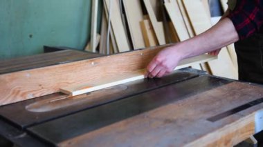 İnşaat işçisi dairesel testere ile tahta kesiyor.