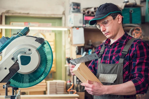 Der Arbeiter fertigt die Maße des Holzbrettes an — Stockfoto