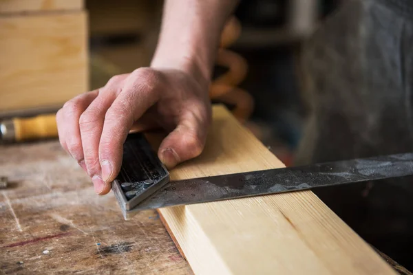 El trabajador hace las medidas de la tabla de madera — Foto de Stock