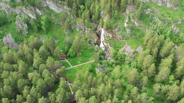 Dron latający nad zielonym lasem z wodospadem w górach Ałtaju. — Wideo stockowe