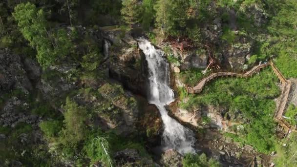 Altay dağlarında şelale ile yeşil bir orman üzerinde uçan Drone. — Stok video