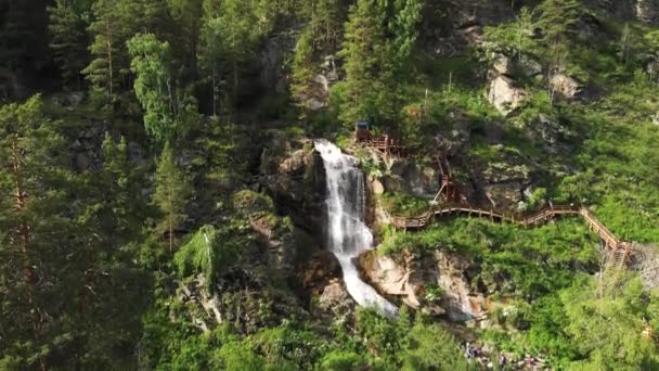 Drohne fliegt über grünen Wald mit Wasserfall im Altai. — Stockvideo