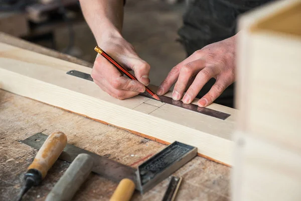 İşçi ölçümleri bir ahşap tahta yapar — Stok fotoğraf