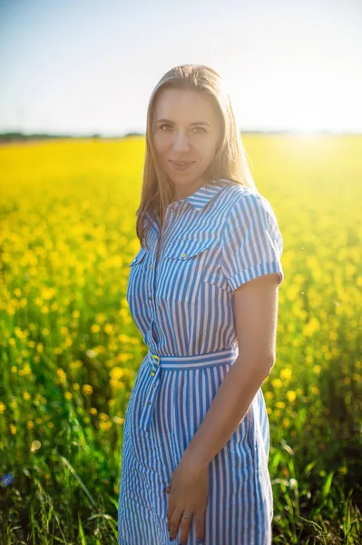 Bella donna in campo con fiori gialli — Foto Stock