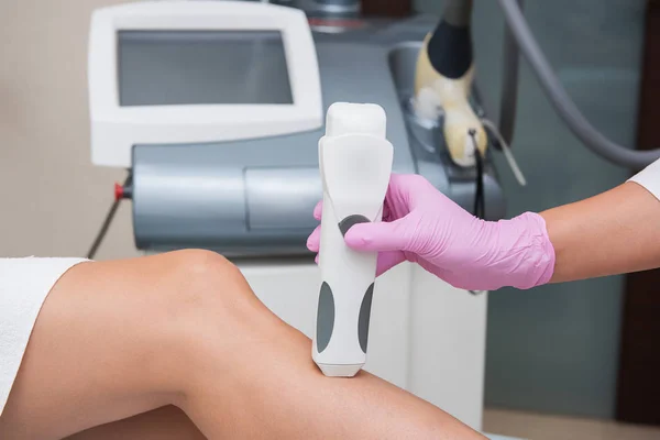 Especialista faz medições de tom de pele em uma perna de mulher — Fotografia de Stock