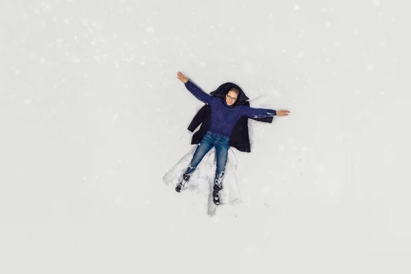 Widok z lotu ptaka się kobieta, leżącego w śniegu — Zdjęcie stockowe