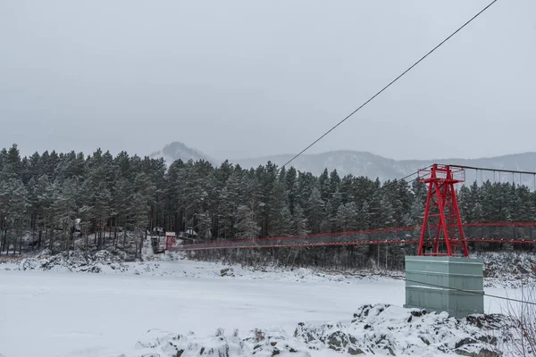 Suspensão ponte suspensa acima do inverno rio congelado — Fotografia de Stock