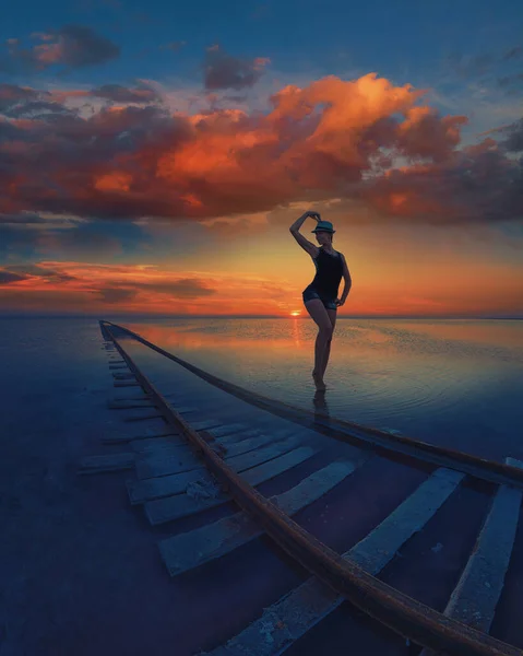 Женщина на закате на солёном озере — стоковое фото