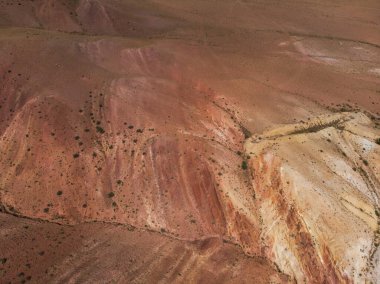 Mars 'ın yüzeyini andıran dokulu sarı nad kırmızı dağlarının havadan çekilmiş görüntüsü.