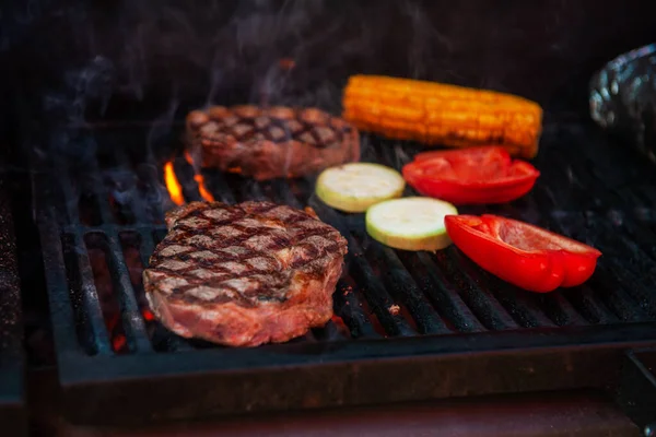 Hovězí steaky na grilu s plamenama — Stock fotografie