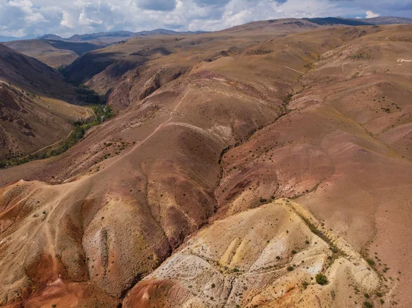 Fotografia aérea das texturizadas montanhas amarelas nad vermelhas que se assemelham à superfície de Marte — Fotografia de Stock