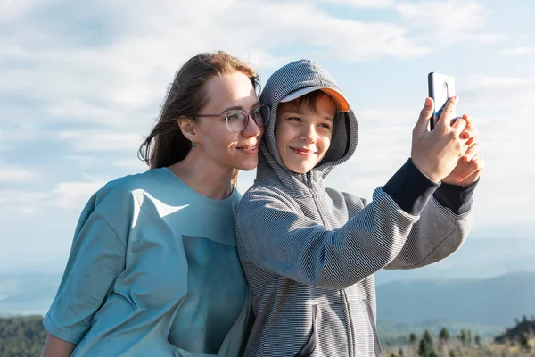 Uma criança tira uma selfie em um smartphone com a mãe — Fotografia de Stock