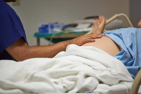 Médico examinando el vientre de mujer embarazada — Foto de Stock