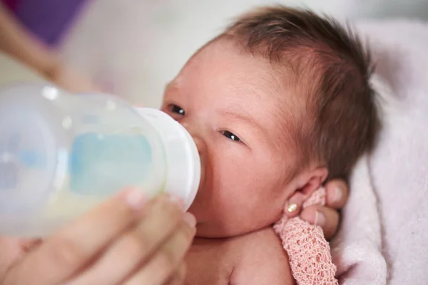 Mom feeding newborn from plastic bottle — Stock Photo, Image