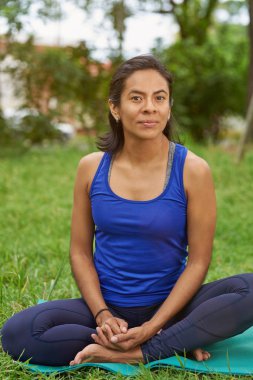 Genç kadın oturup yoga mat