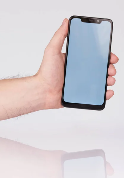 Hand holding smartphone with notch — Stock Photo, Image