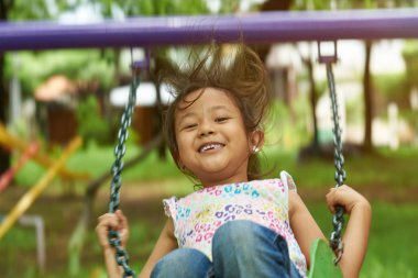 Sallanan ve gülümseyen Asyalı kız