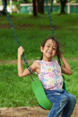 Sallanan ve gülümseyen Asyalı kız