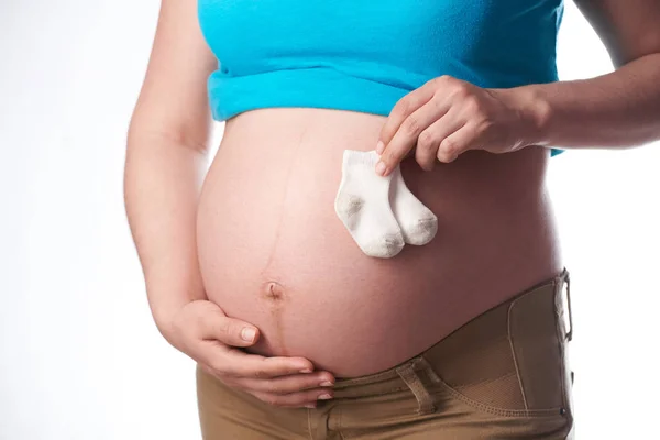 Donna incinta tenere calzini bambino — Foto Stock