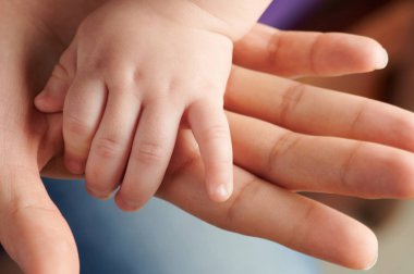 Small baby hand on mom palm