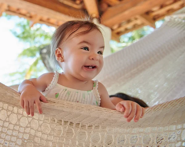 微笑的小女孩躺在热带背景的吊床上 — 图库照片