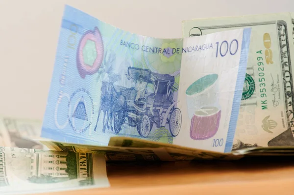 Billete de cien córdobas sobre fondo de dólar — Foto de Stock