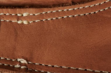Kahverengi deri üzerinde beyaz dikiş 