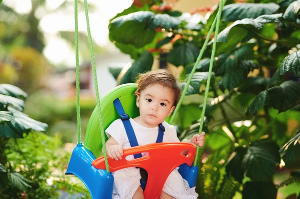 Bebé niña sentarse en columpios — Foto de Stock