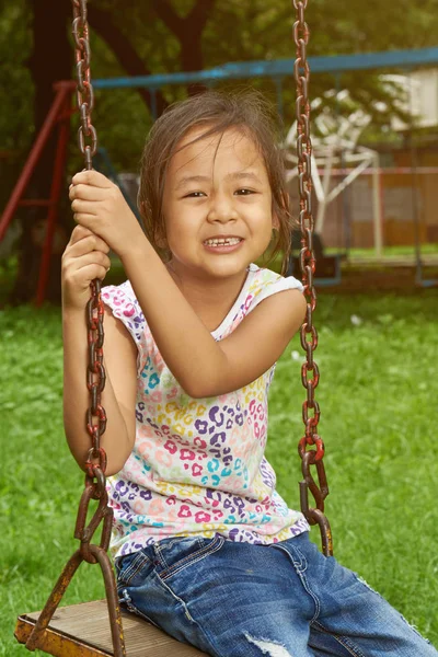 Asiatico ragazza sorridente su un swing — Foto Stock