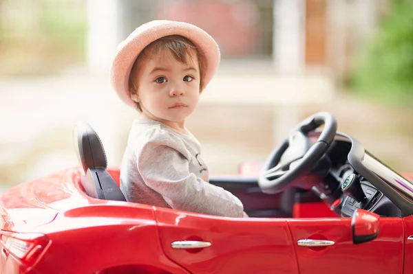 Linda niña sentarse en coche de juguete — Foto de Stock