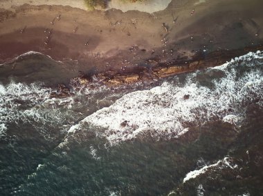 İnsanlar sahilde kalır.