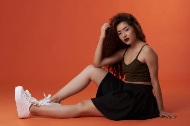 Genç esmer kadın yere otur.