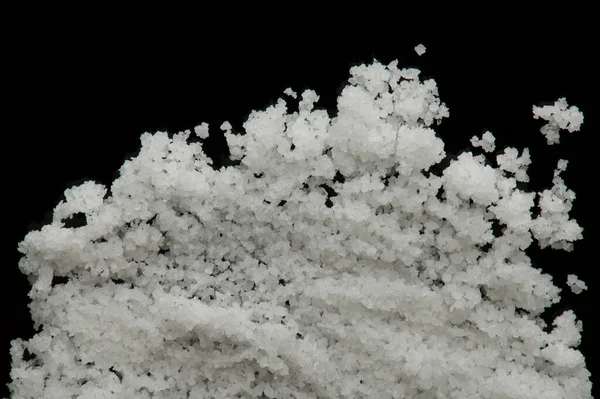 Crystals of sea salt isolated on black background close up view
