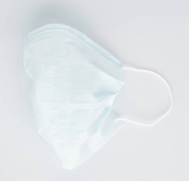 Katlanmış yüz maskesi beyaz arkaplanda izole edilmiş, yakın plan görünümü