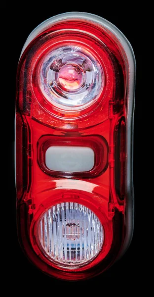 Red rear bicycle lamp with button isolated close up view