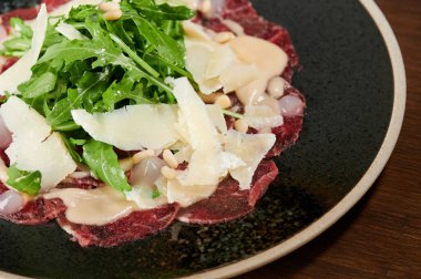 Sağlıklı atıştırma teması. Dilimlenmiş et carpaccio tabak makro yakın görüş