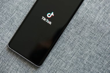 New York, ABD - 18 Haziran 2020: Akıllı telefon ekranında TikTok uygulaması başlatılıyor Gri arkaplan görüntüsünü kapat