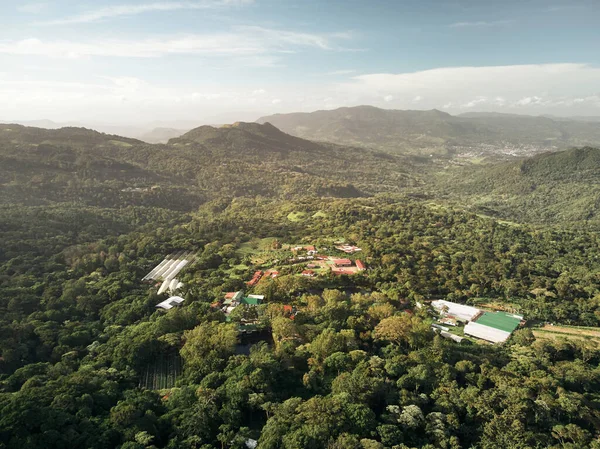 Eco farm in green hills forest above drone view